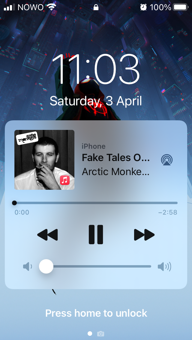 Screenshot of the lock screen of an iPhone SE while music is playing. It's displaying a tiny, tiny cover of the album 'Whatever People Say I Am, That's Who I'm Not', by The Artic Monkeys. In the UI it's impossible to read the full name of the band or of the album.